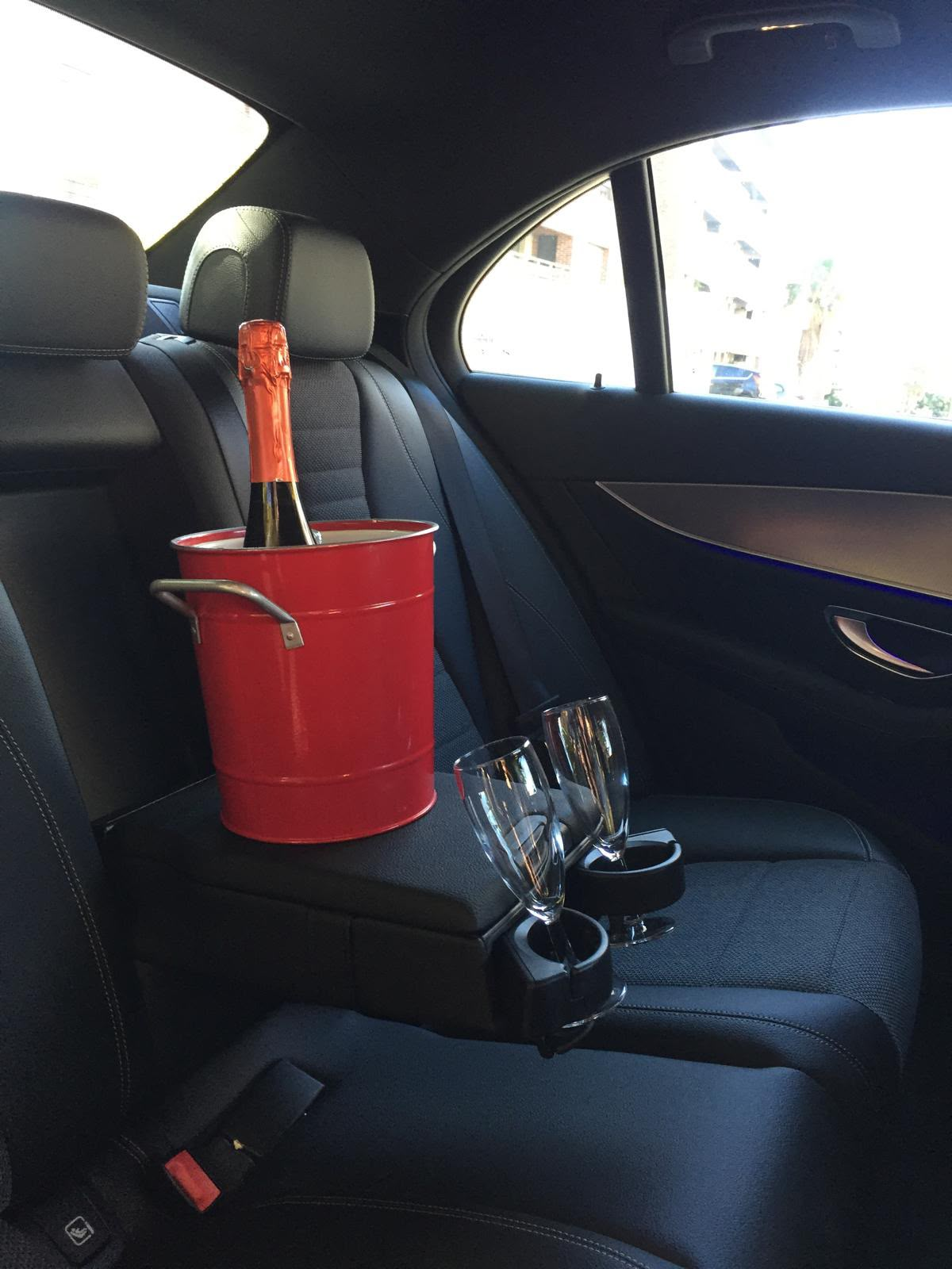Interior VICDREAM com champanhe e copos — bancos em pele preta de uma Mercedes